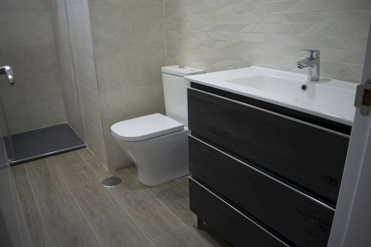 Detalle plato de ducha, inodoro compacto de baño mueble de lavabo